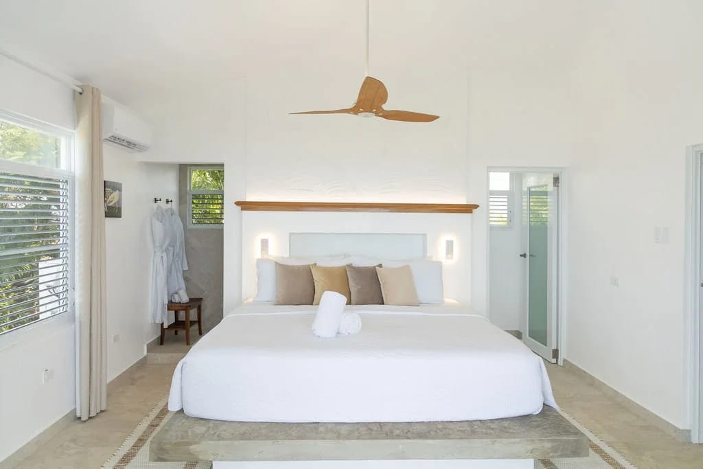 Master suite with a king bed under a vaulted ceiling and paddle fan